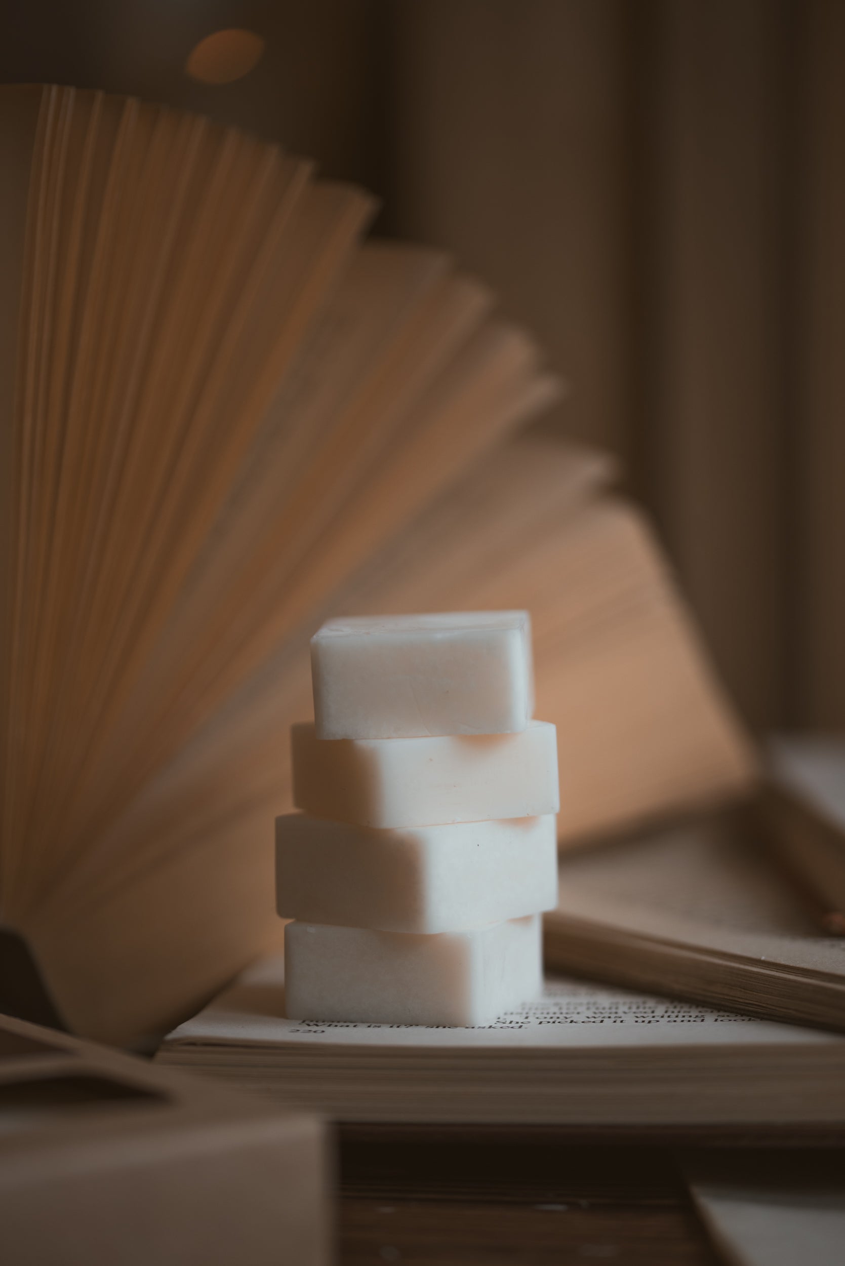 Stack of wax melt cubes with a book fanned out in the background