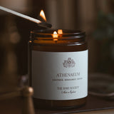Candle being lit with a match, featuring the Athenaeum label on a blurred background.