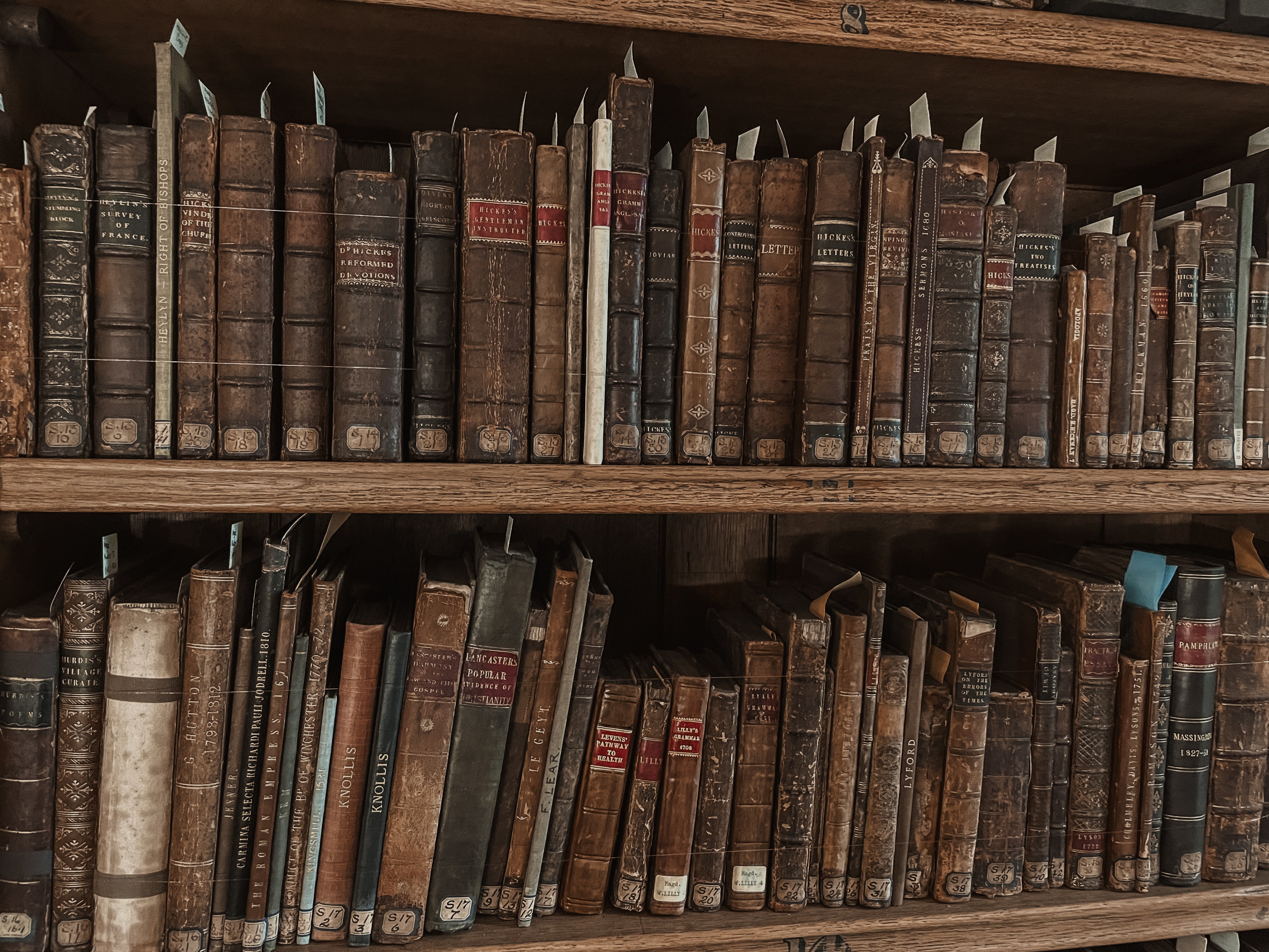 Wooden bookshelf filled with old, worn books.