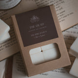 The Quad wax melt cubes in kraft packaging with a dark brown label
