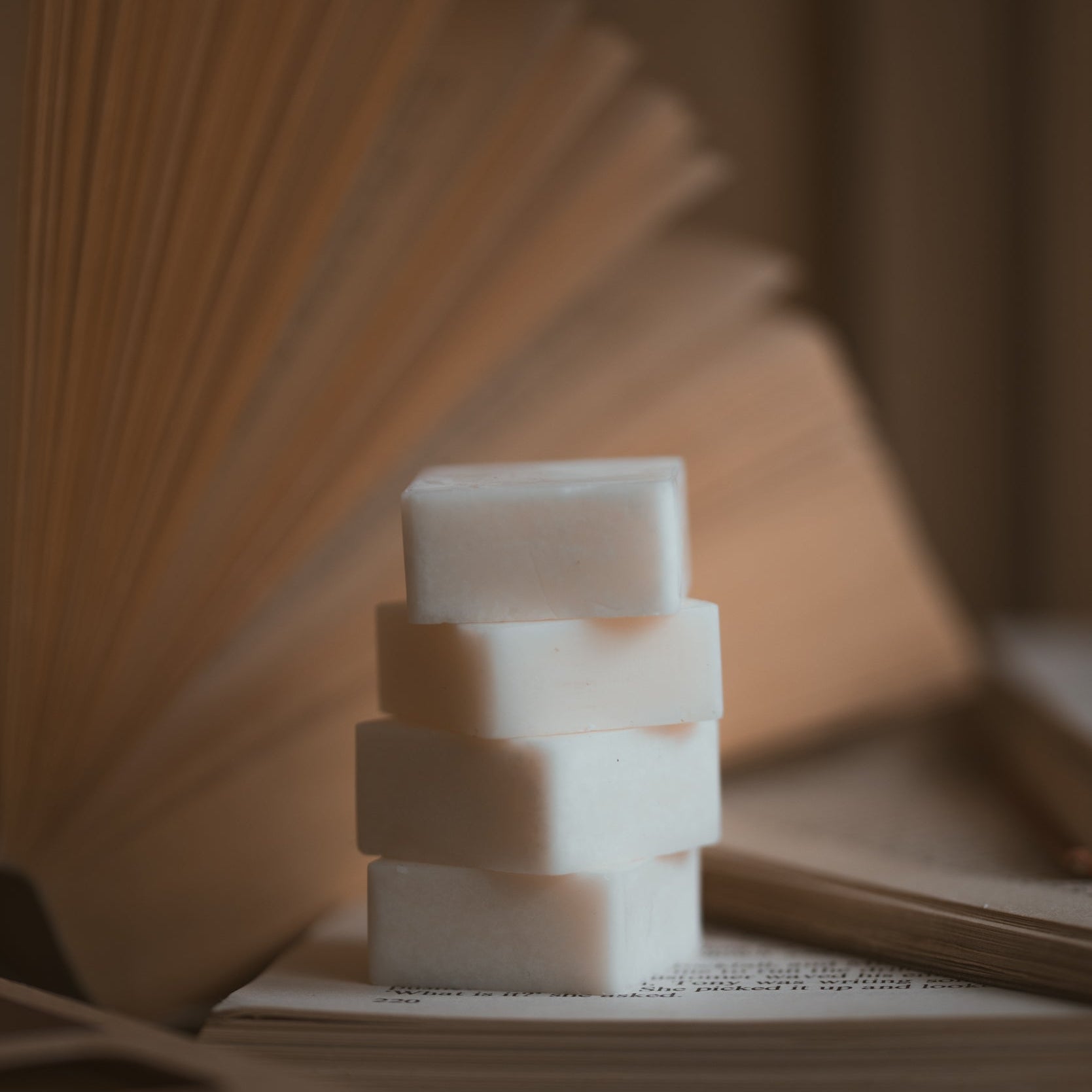 Stack of wax melt cubes on a textured surface with a blurred background